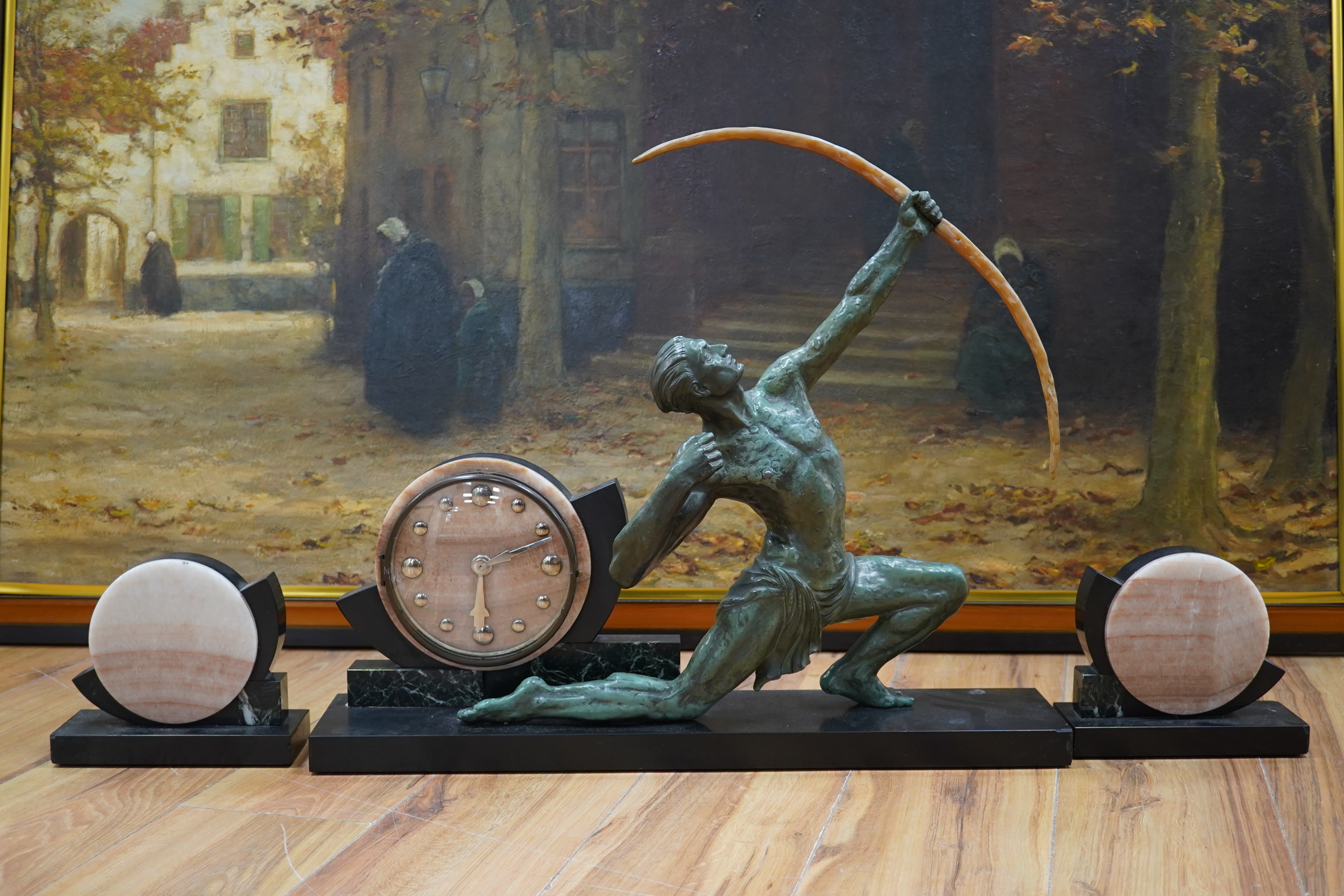 A French Art Deco spelter and marble ‘archer’ clock garniture, 60.5cm wide, 51.5cm high. Condition - fair to good